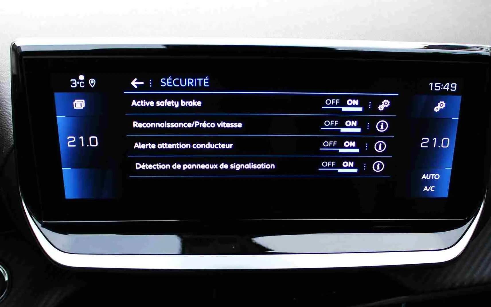 Écran central du tableau de bord du Peugeot 2008 II affichant les réglages de sécurité et la climatisation à 21°C.