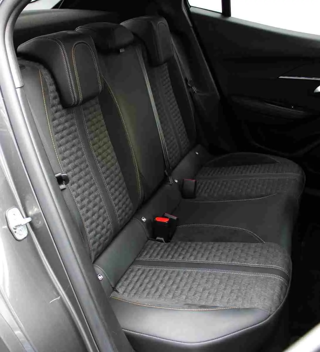 Vue intérieure côté gauche des sièges arrière en tissu et cuir noir avec surpiqûres jaunes du Peugeot 2008 gris platinium 2022.