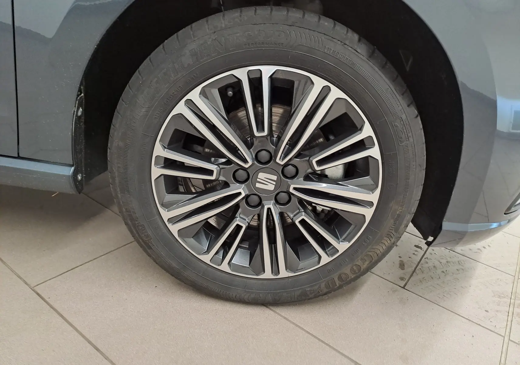 Gros plan sur la roue avant gauche d'une SEAT Ibiza 2025 gris magnétique avec jante alliage multifacettes.