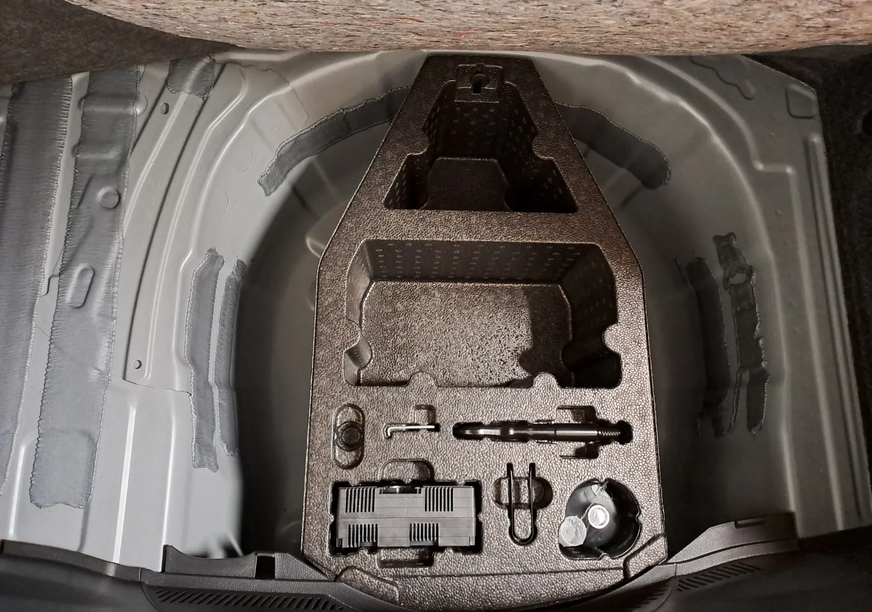 Vue du compartiment de rangement sous le coffre de la SEAT IBIZA 1.0 TSI 115 DSG7 COPA 2025, sans accessoires visibles.