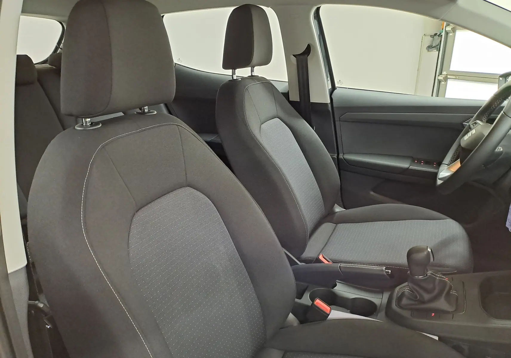 Vue intérieure côté droit montrant les sièges avant gris foncé et la console centrale de la SEAT IBIZA 2025.