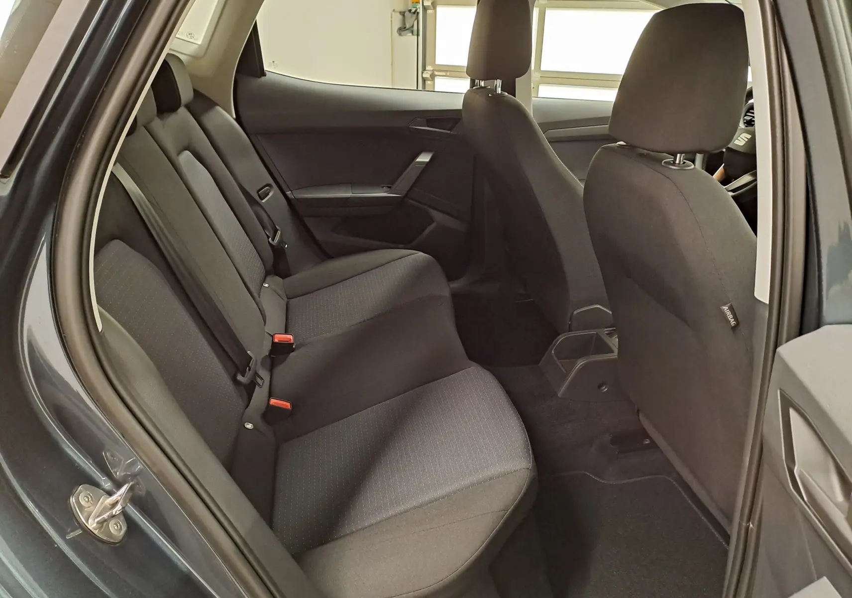 Vue intérieure côté gauche montrant les sièges arrière en tissu noir du SEAT Ibiza 2025 gris magnétique.