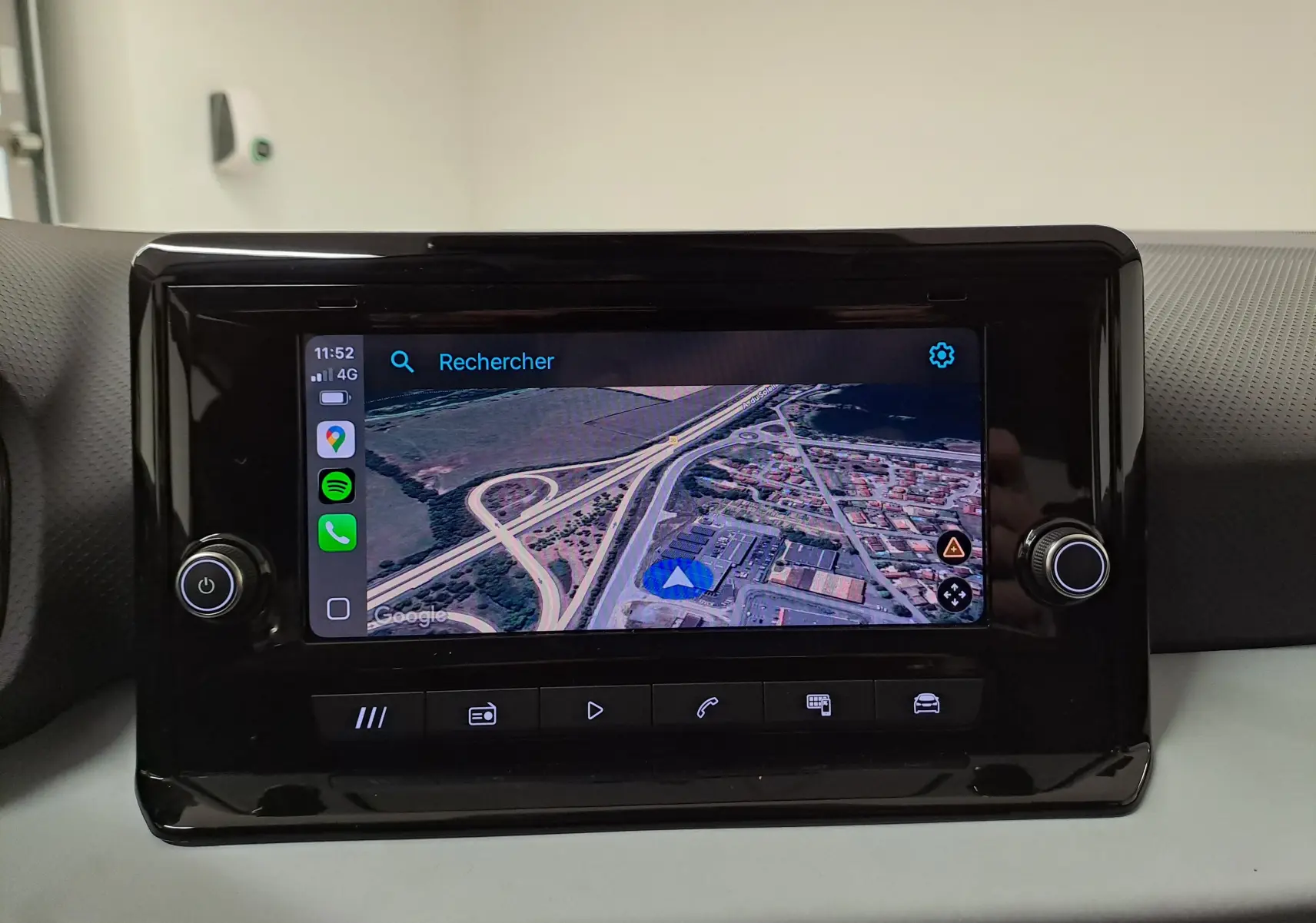 Écran tactile central de la SEAT Ibiza 2025 affichant une carte GPS en vue satellite, entouré de commandes noires brillantes.