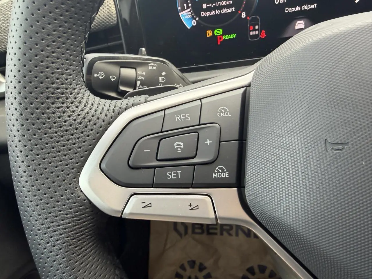 Gros plan sur le volant multifonction cuir du Volkswagen T-Roc 2026, boutons de régulateur de vitesse et tableau de bord numérique.