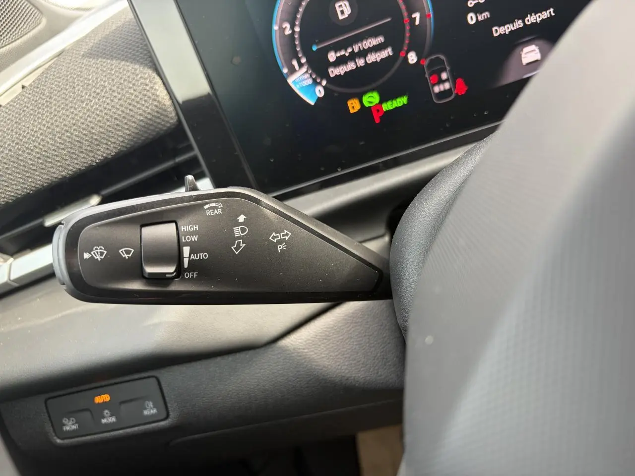 Gros plan sur la manette d’essuie-glace gauche du Volkswagen T-Roc 2026, tableau de bord numérique en arrière-plan.