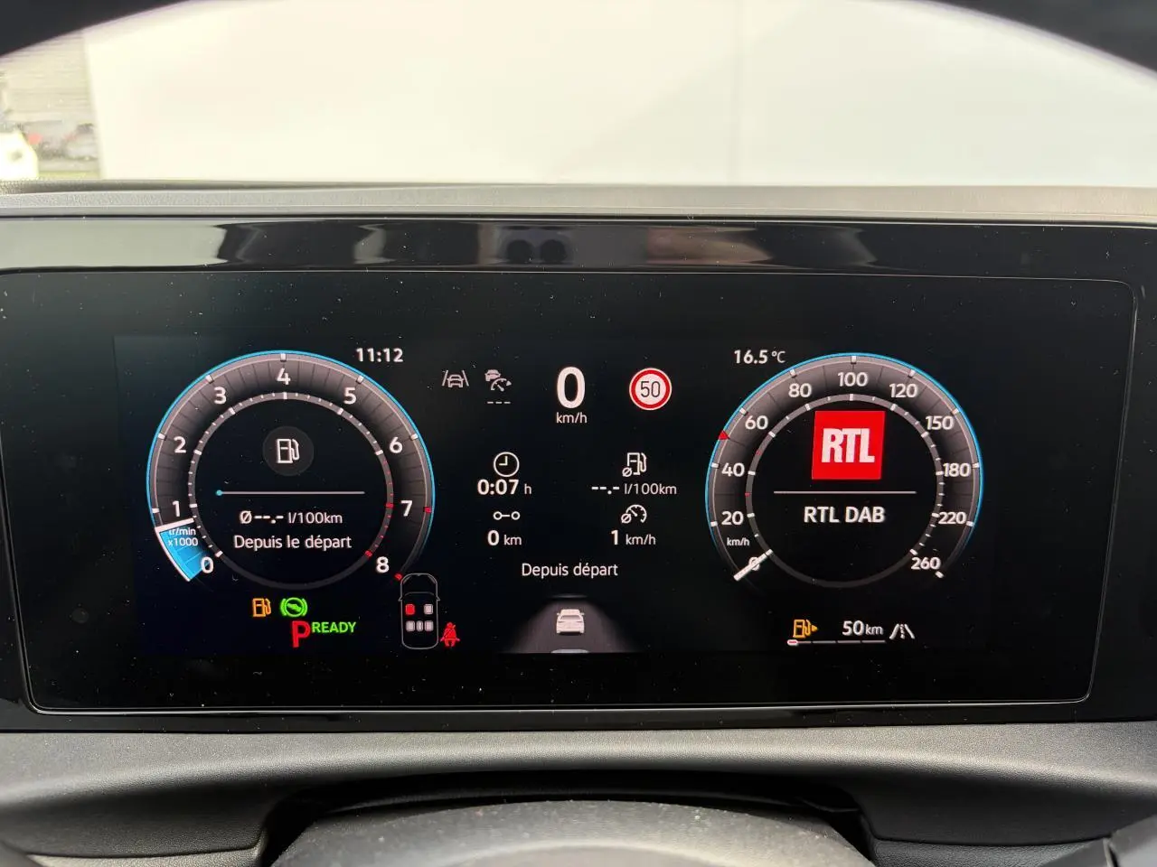 Tableau de bord numérique du Volkswagen T-Roc 2026 affichant vitesse, compte-tours et radio RTL en vue frontale.