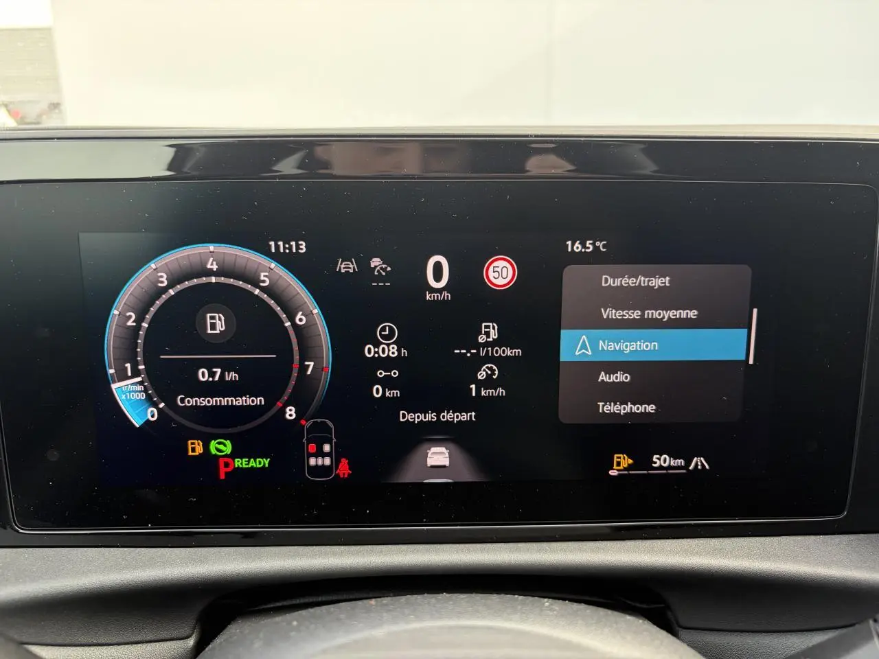 Affichage digital du tableau de bord du Volkswagen T-Roc avec menu navigation et indicateurs de consommation et vitesse.