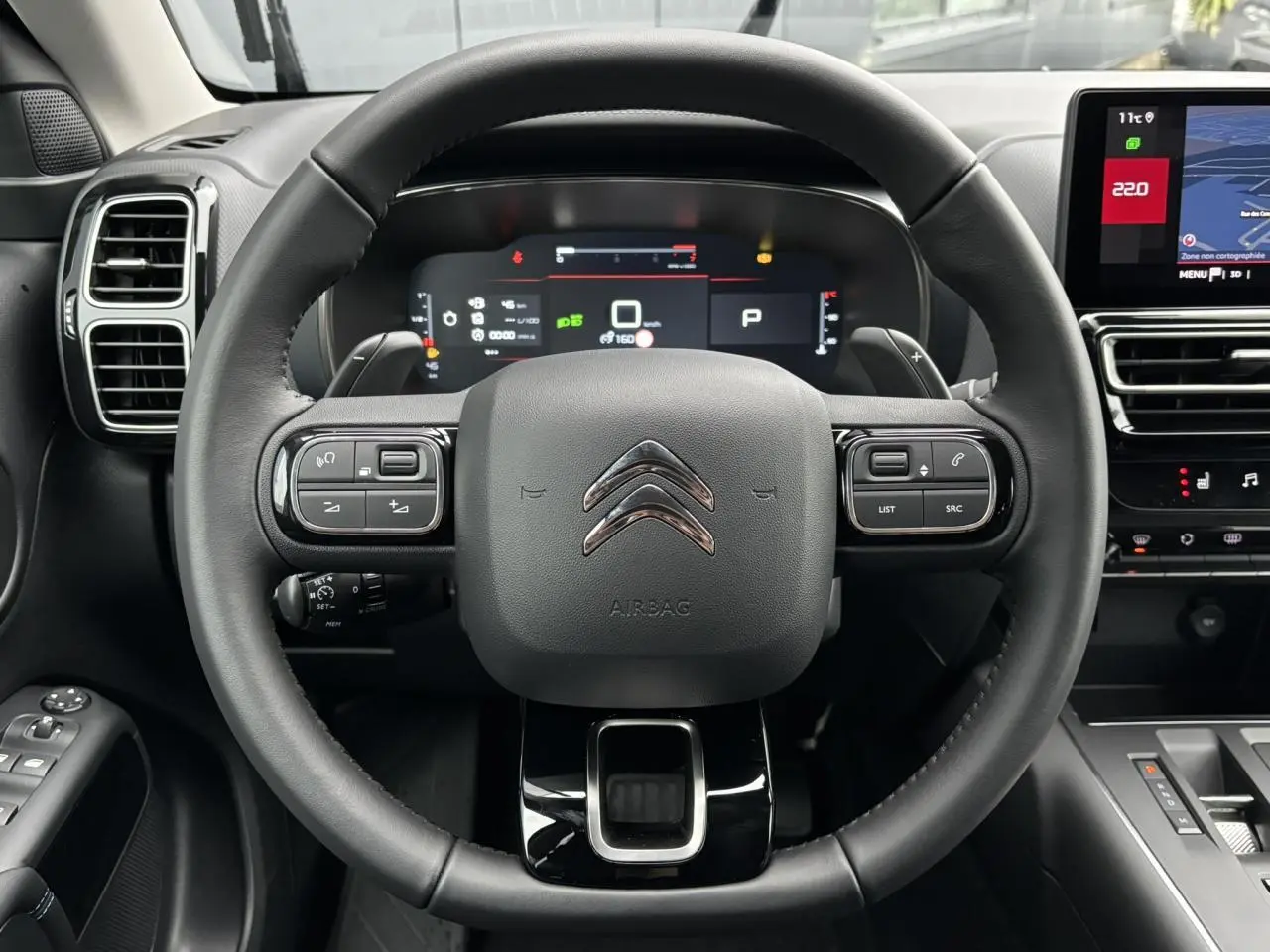 Vue frontale du volant cuir noir du Citroën C5 Aircross 2025 avec tableau de bord numérique et écran tactile.