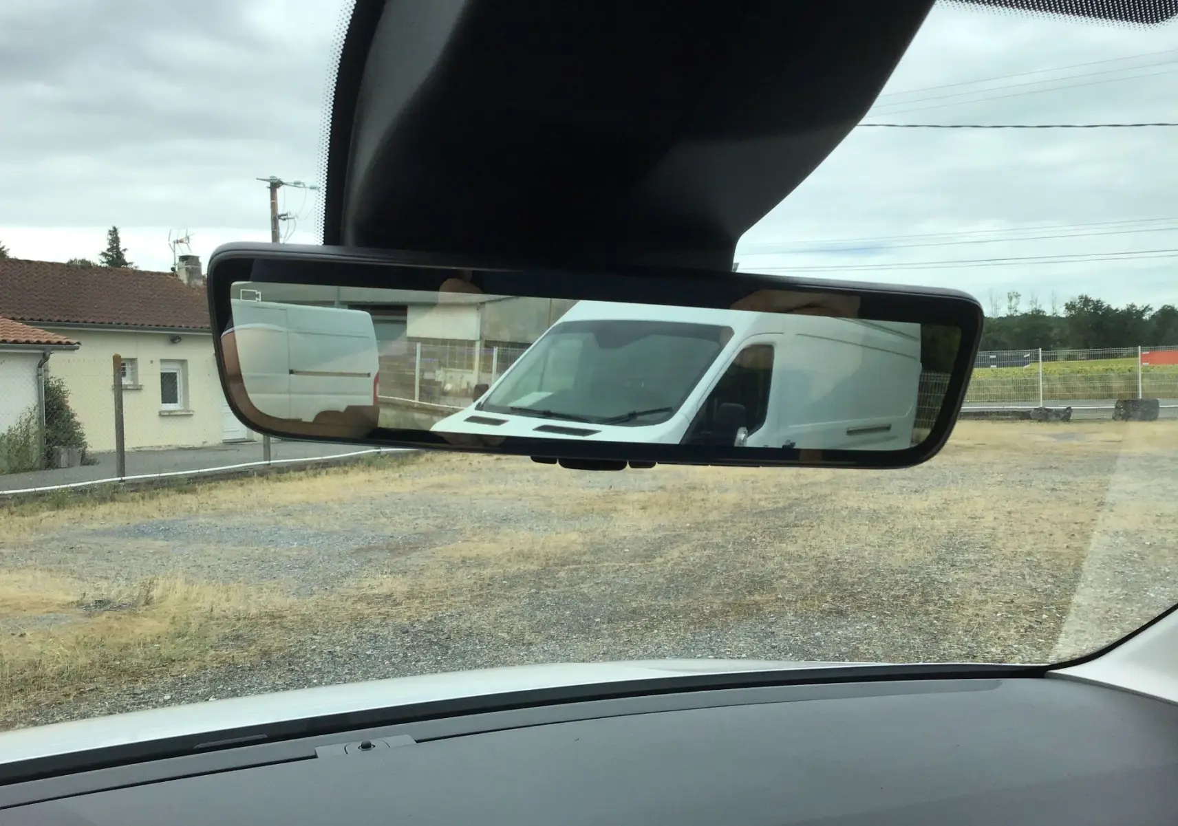 Vue depuis l'intérieur sur le rétroviseur central montrant l'arrière blanc du Peugeot Partner XL Heavy.