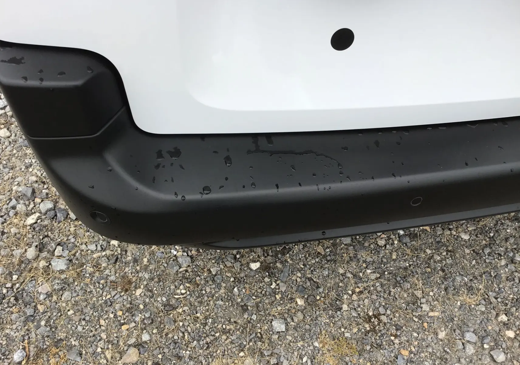 Gros plan sur le pare-chocs arrière noir et blanc du Peugeot Partner XL 2026, avec capteurs de recul visibles.