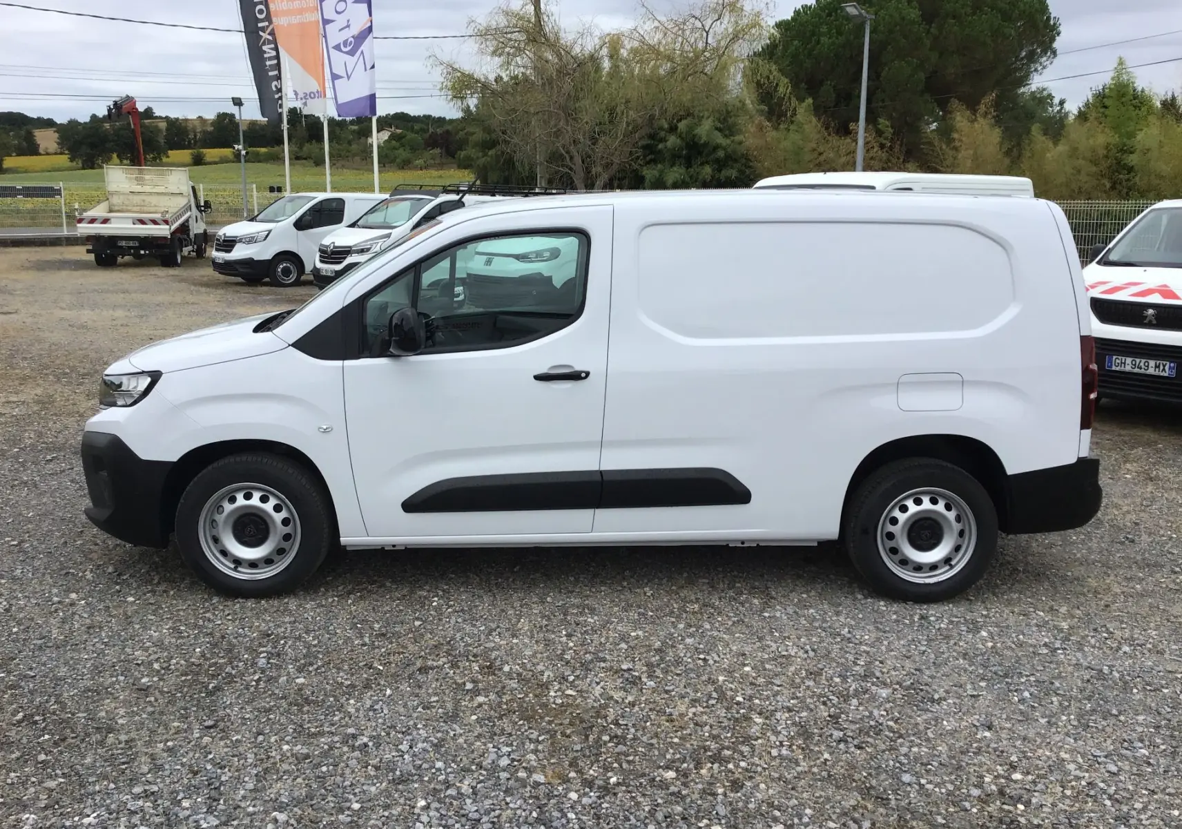 Vue de profil côté gauche d’un utilitaire Peugeot Partner blanc 2026 avec porte latérale coulissante et jantes acier.