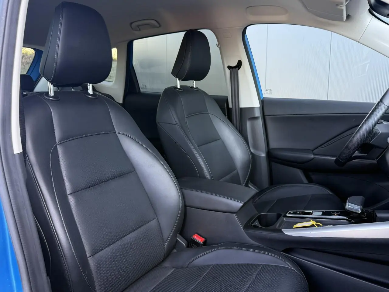 Vue intérieure côté droit du MG ZS 1.5 Hybrid+ 197 Luxury bleu Como, sièges tissu/similicuir noirs et accoudoir central.