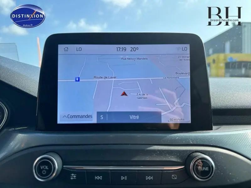Écran tactile central de la Ford Focus 2019 affichant la navigation GPS, avec commandes audio en dessous.
