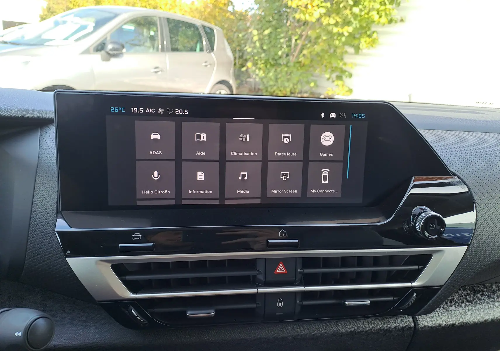 Tableau de bord du Citroën C4 hybride 2025 avec écran tactile central affichant les menus principaux, intérieur noir.