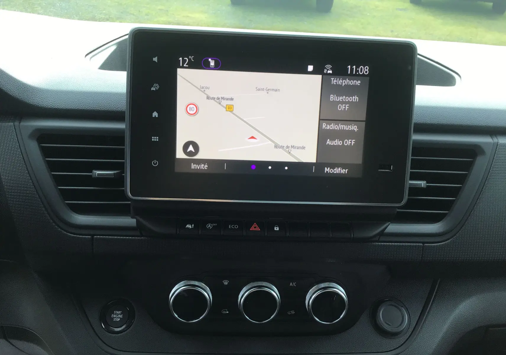 Tableau de bord du Renault Trafic Fourgon 2025 avec écran tactile 8 pouces affichant la navigation, boutons de climatisation et démarrage.