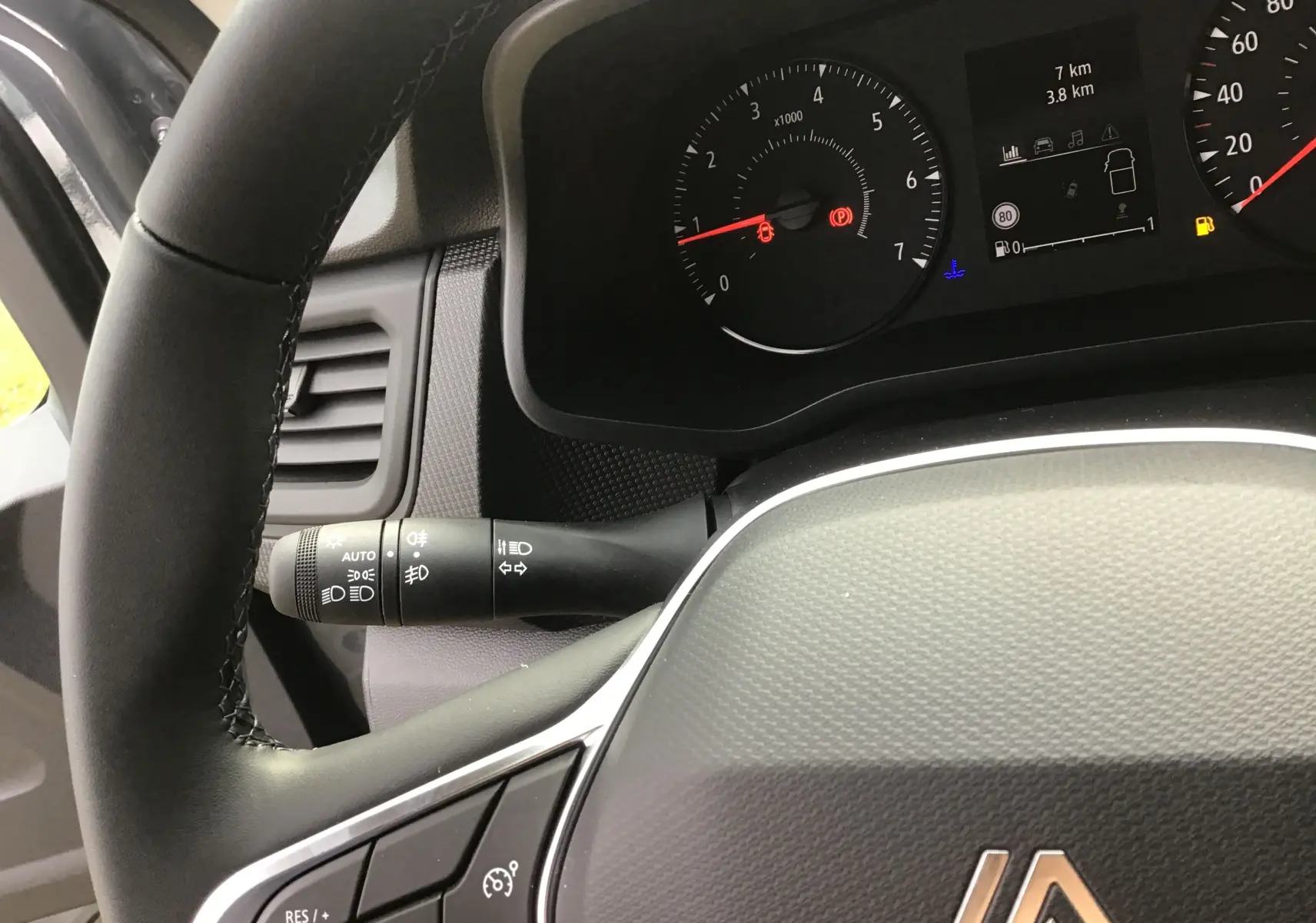 Vue rapprochée du volant et du tableau de bord du Renault Trafic Fourgon gris urbain, affichant les compteurs et commandes.