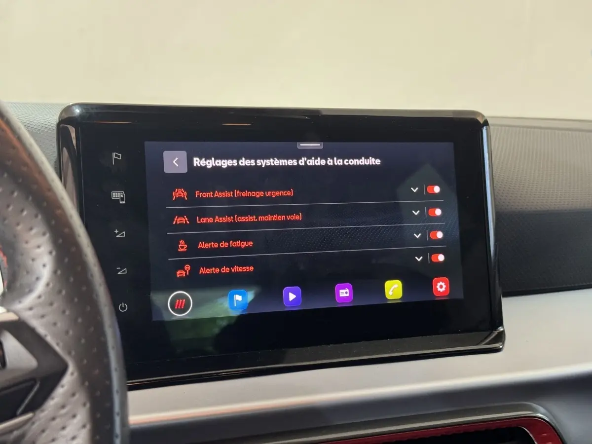 Écran tactile central affichant les réglages d'aide à la conduite dans l'habitacle d'une SEAT IBIZA rouge 2024.