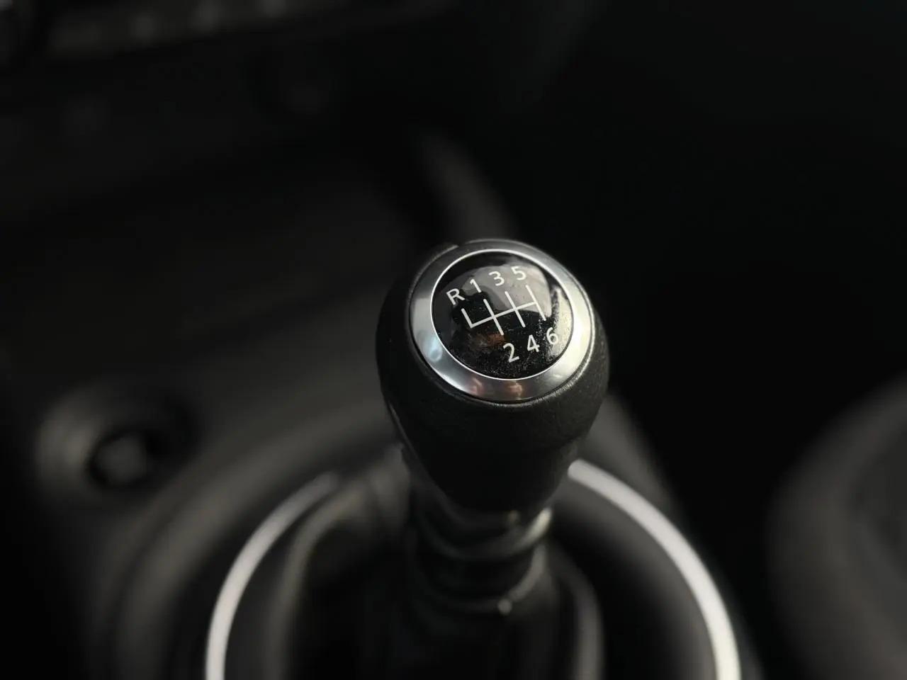 Gros plan sur le levier de vitesses manuel noir du Nissan Juke 2025, version essence Dark Grey.