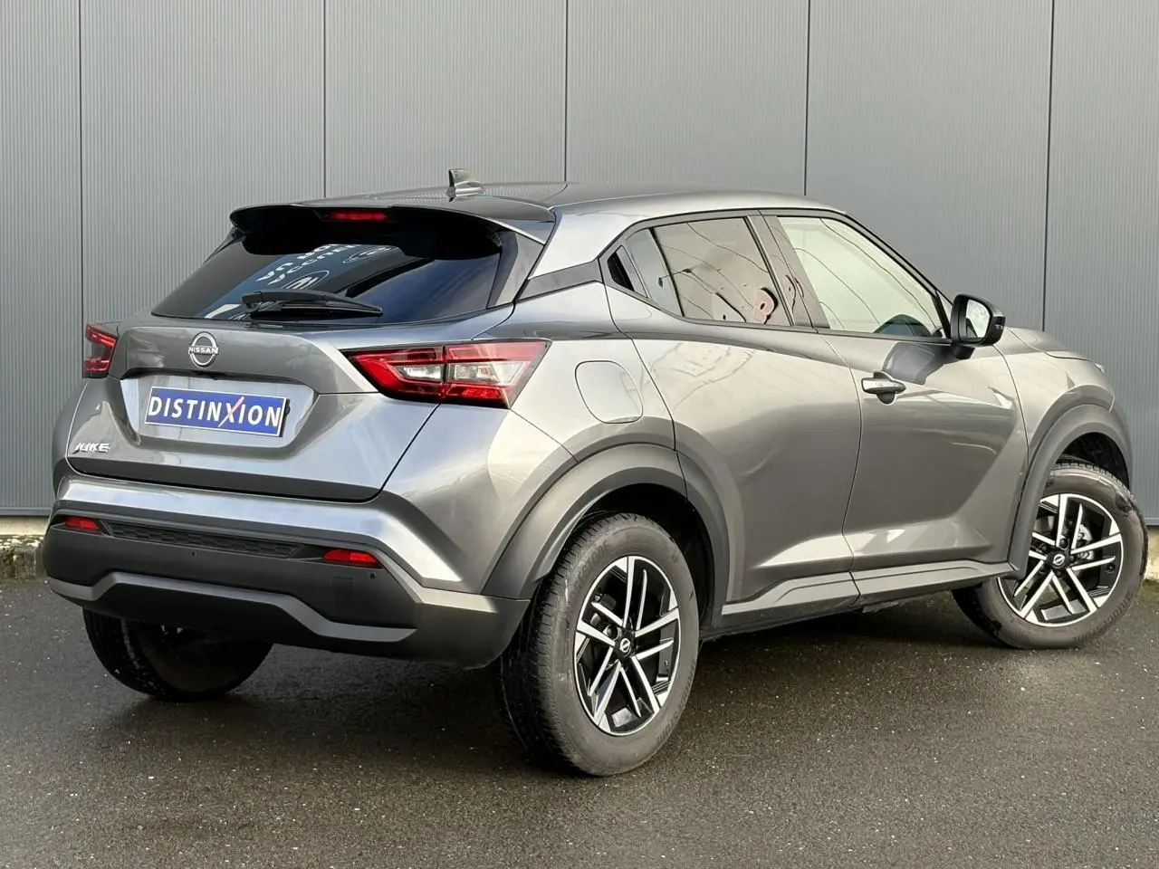 Nissan Juke 2025 gris foncé en 3/4 arrière droit, avec jantes alliage 17'' et vitres teintées.