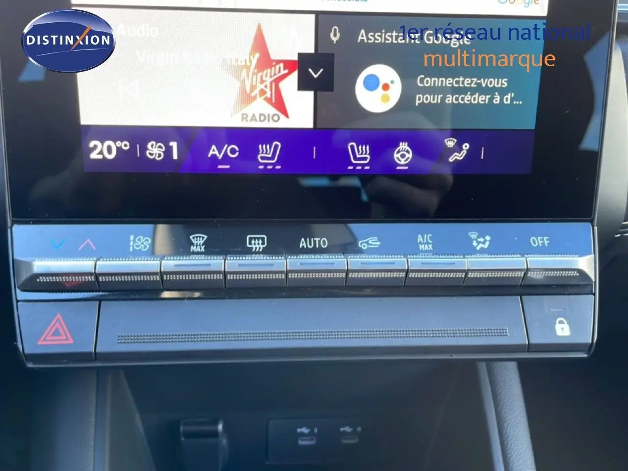 Gros plan sur la console centrale tactile du Renault Symbioz 2025 bleu Iron Metal, affichant les commandes climatisation et sièges chauffants.