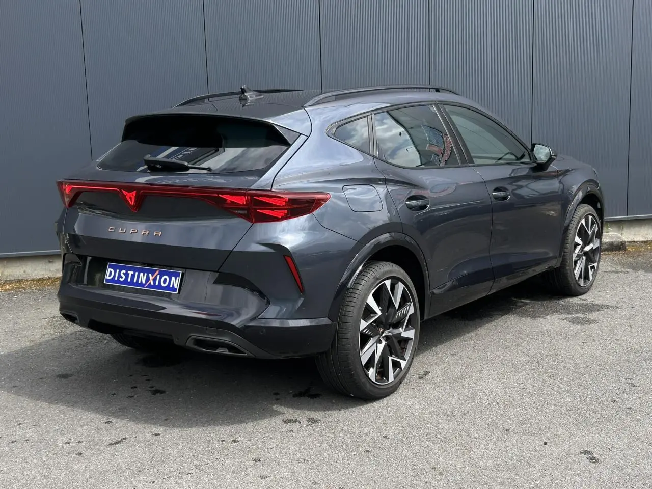 Vue 3/4 arrière droite d'une CUPRA Formentor gris magnétique avec jantes alliage 19 pouces et feux arrière Tri-LED.