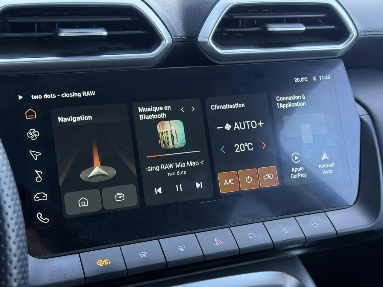 Vue rapprochée de l’écran tactile central du MG ZS 1.5 Hybrid+ 197 Luxury avec interface multimédia et climatisation affichée.