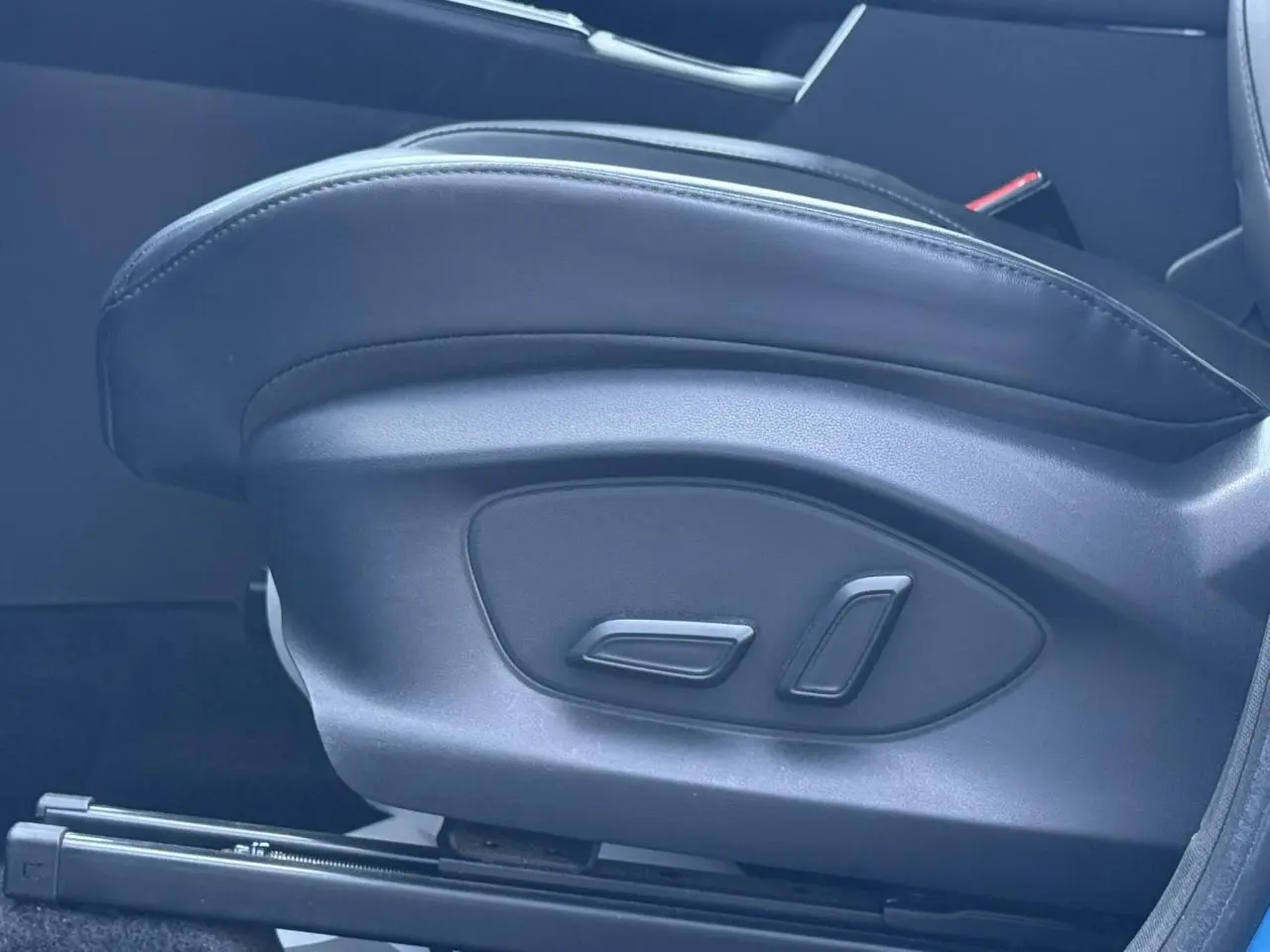 Gros plan sur les commandes électriques du siège conducteur noir du MG MOTOR ZS 1.5 Hybrid+ 197 Luxury 2025.