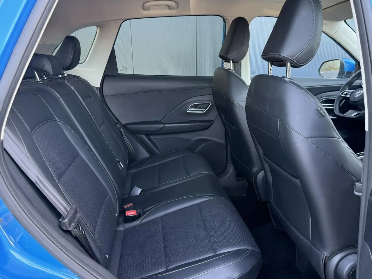 Vue intérieure côté gauche montrant la banquette arrière en tissu et similicuir noir du MG ZS bleu Como 2025.
