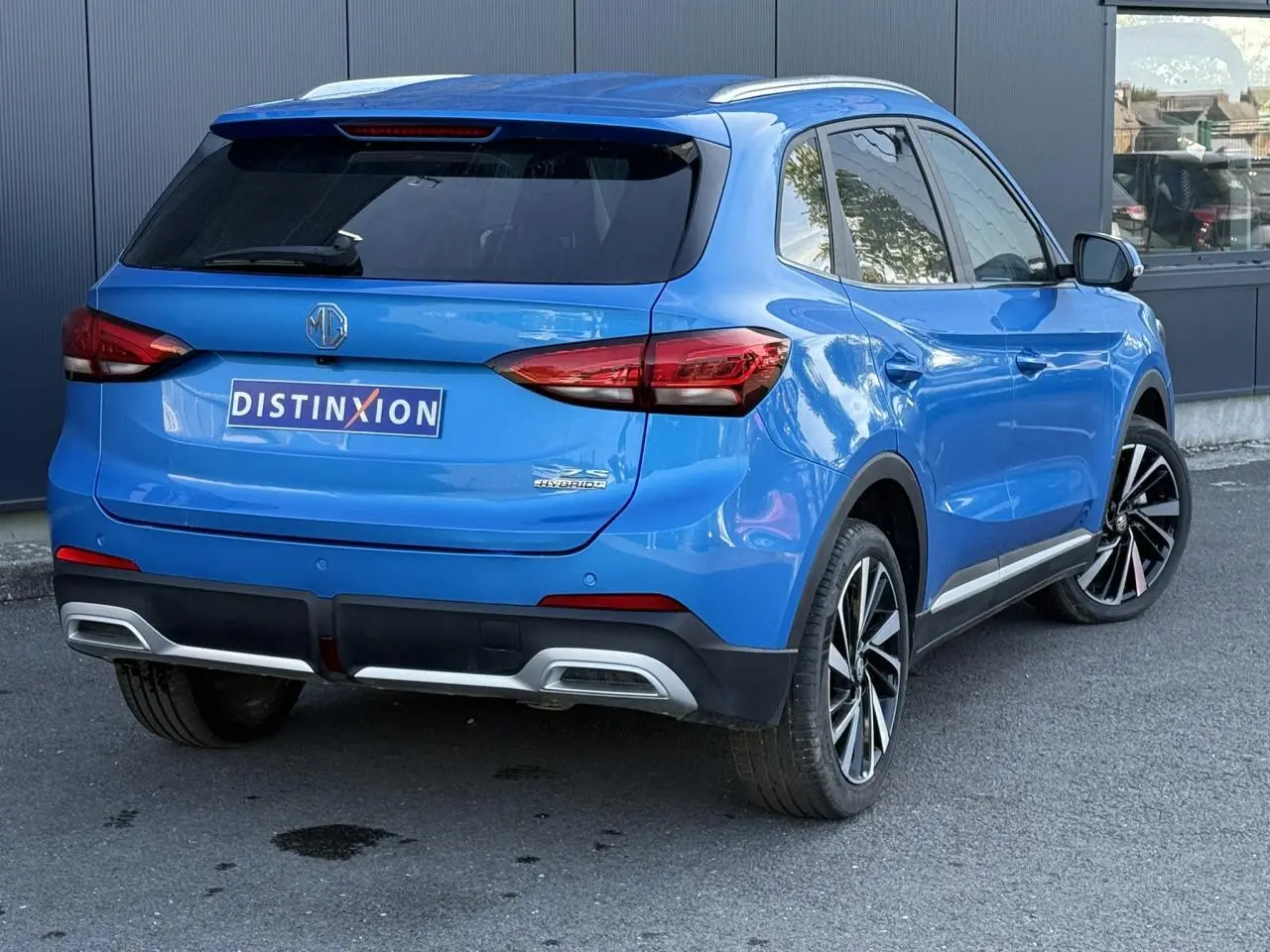Vue 3/4 arrière droite du SUV MG ZS 1.5 Hybrid+ 197 Luxury en bleu Como métallisé avec jantes alliage 18 pouces.
