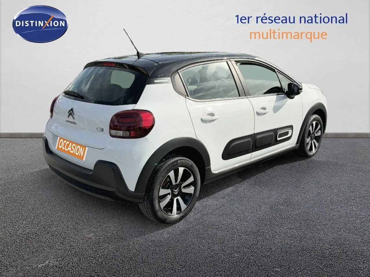 Citroën C3 blanche vue 3/4 arrière droit avec toit noir et protections latérales noires distinctives.