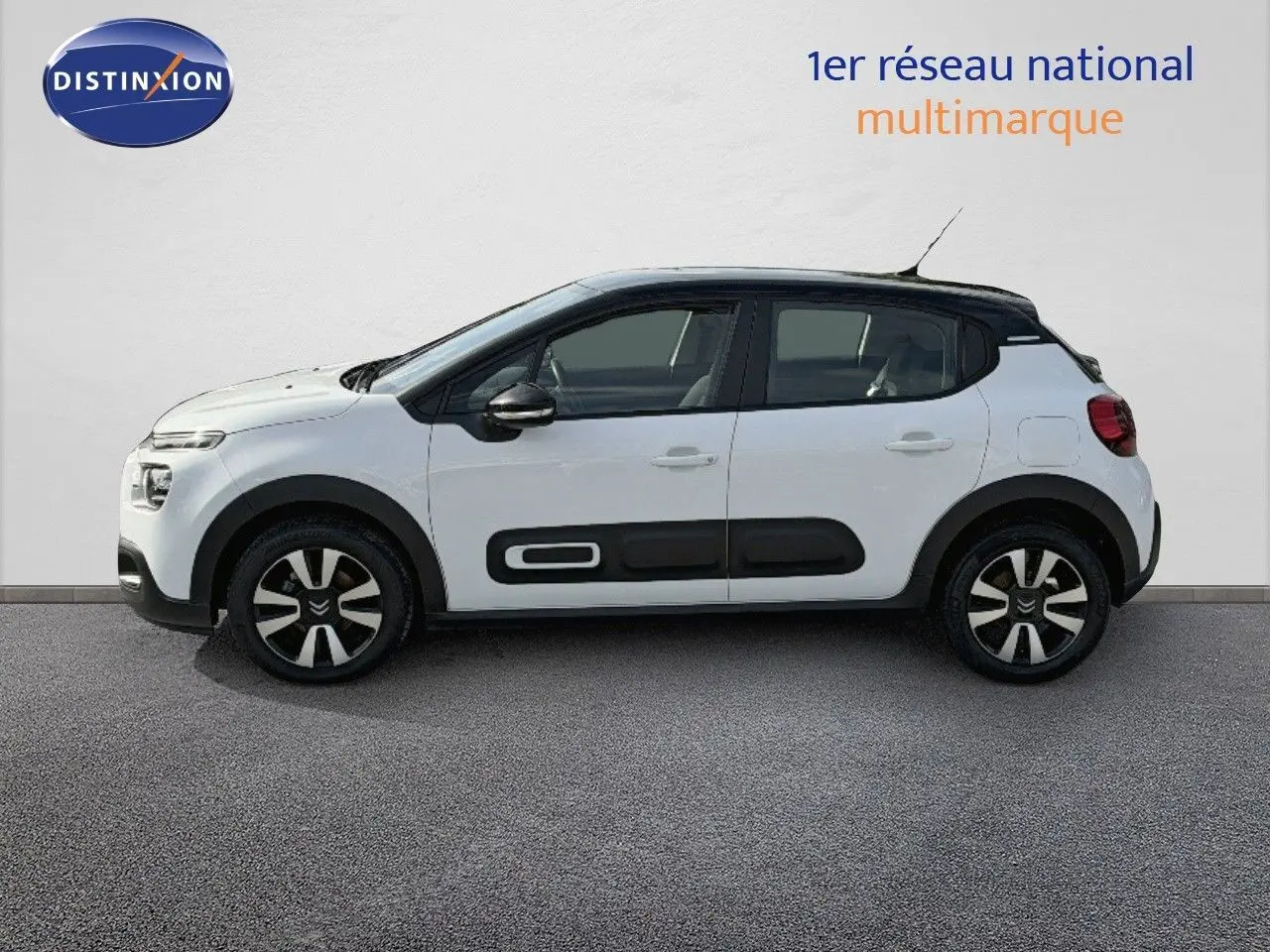 Profil côté gauche d'une Citroën C3 blanche 2021 avec toit noir et protections latérales noires distinctives.