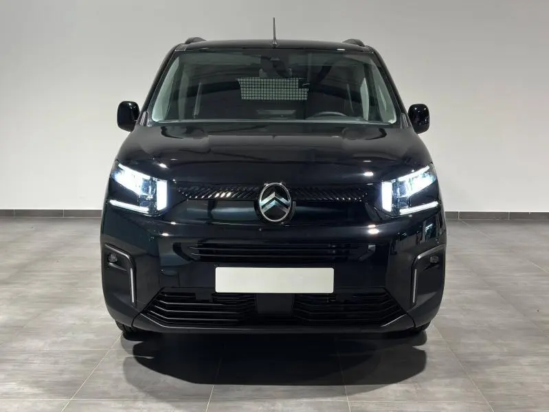 Vue de face du Citroën Berlingo Fourgon noir Perla Nera nacré avec phares LED allumés et calandre distinctive.