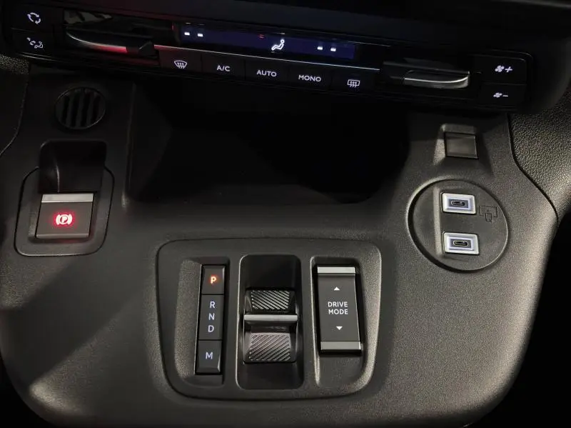 Vue rapprochée de la console centrale noire du Citroën Berlingo 2025 avec commandes de boîte auto et modes de conduite.