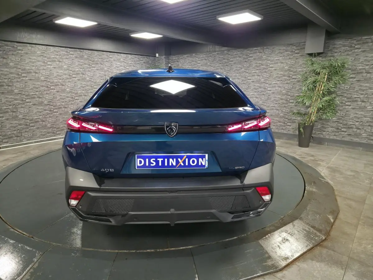 Vue arrière d'une Peugeot 408 hybride rechargeable bleu métallisé, avec feux arrière à LED et logo lion central.