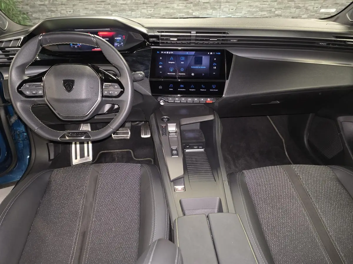 Vue intérieure avant de la Peugeot 408 GT 2024, tableau de bord noir avec écran tactile 10 pouces et volant compact.