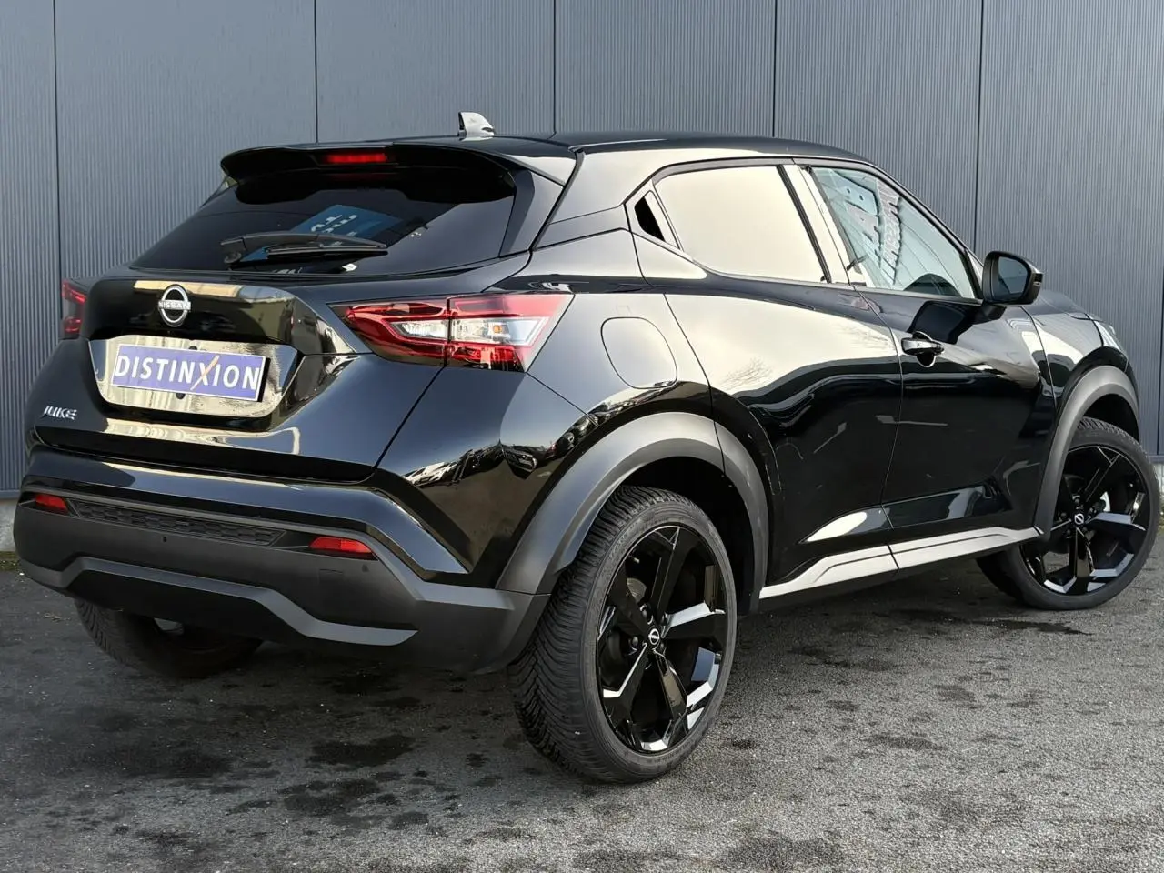 Nissan Juke 2024 Black Pearl en 3/4 arrière droit, avec jantes alliage noires et feux LED distinctifs.
