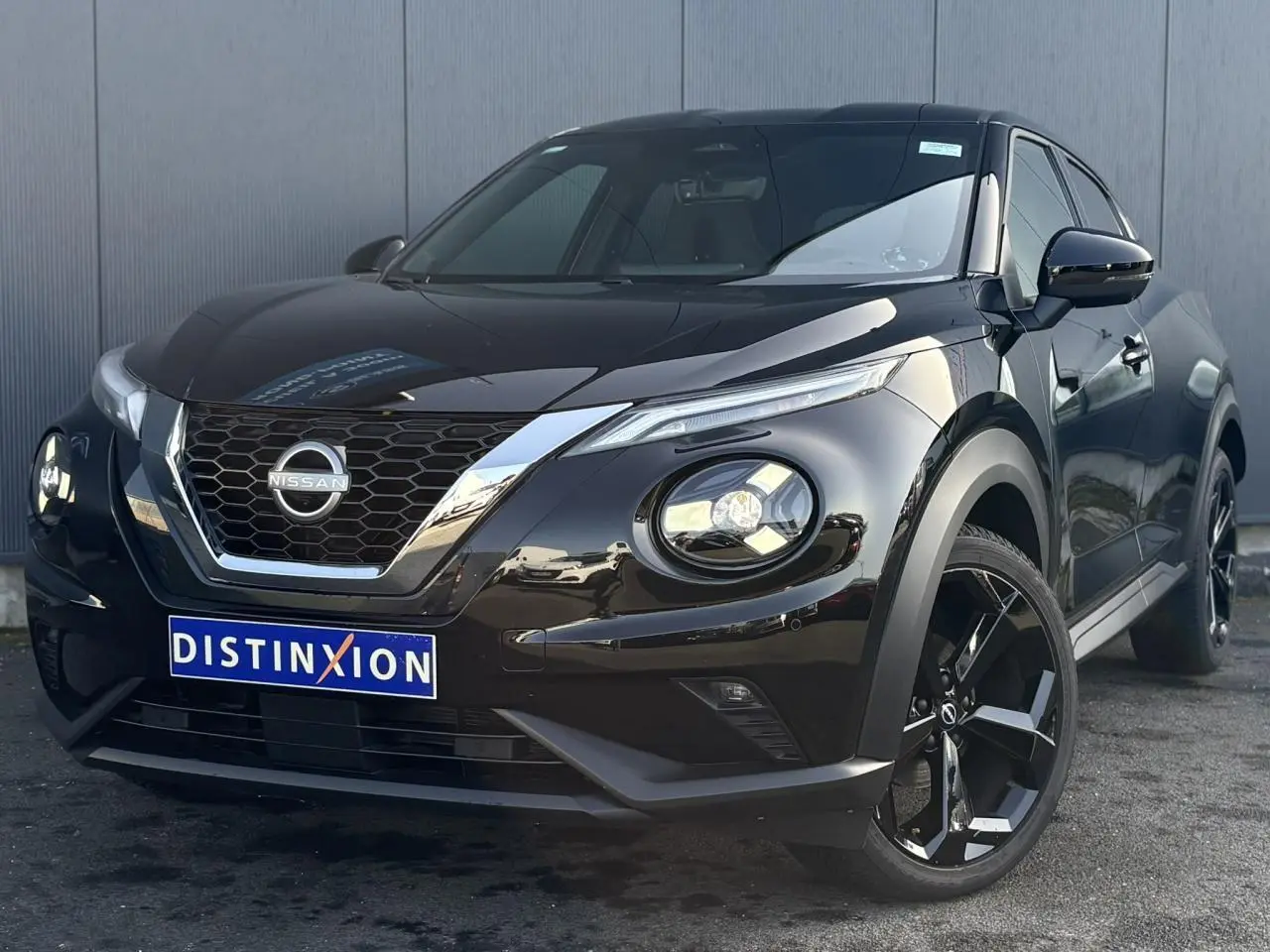 Nissan Juke 2024 Black Pearl en 3/4 avant droit, avec jantes alliage noires et calandre chromée brillante.