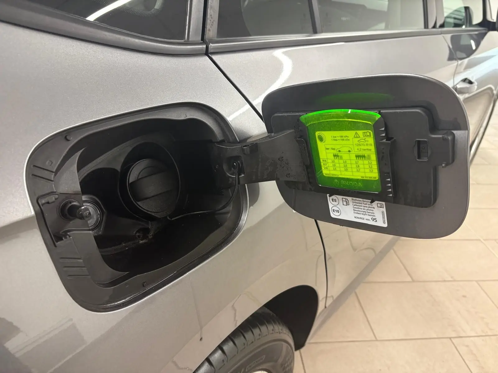 Trappe à carburant ouverte côté gauche d’un Skoda Kamiq 2023 gris graphite avec détails techniques visibles.