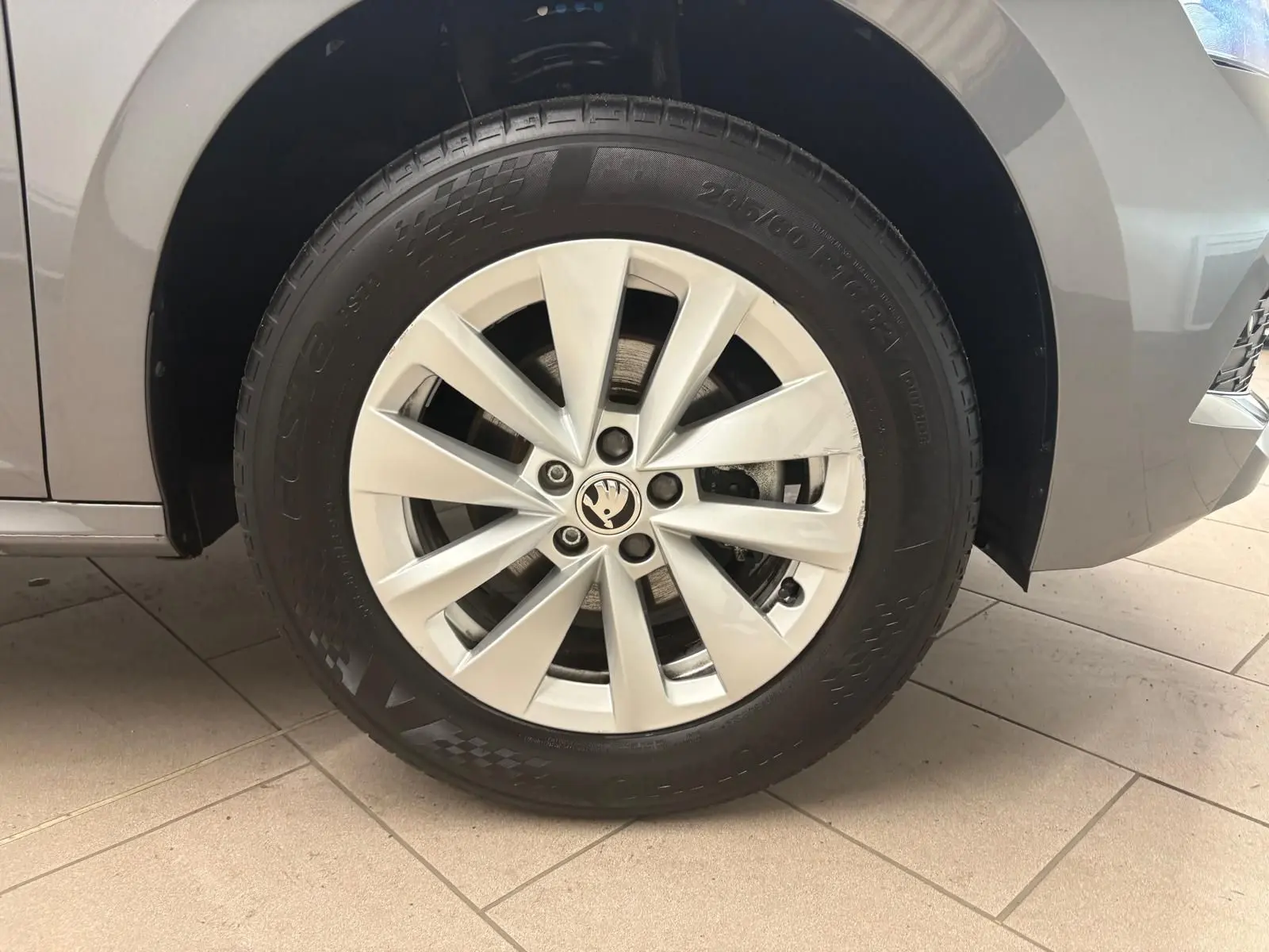 Gros plan sur la roue avant gauche d’un Skoda Kamiq 2023 gris graphite avec jante alliage à dix branches.