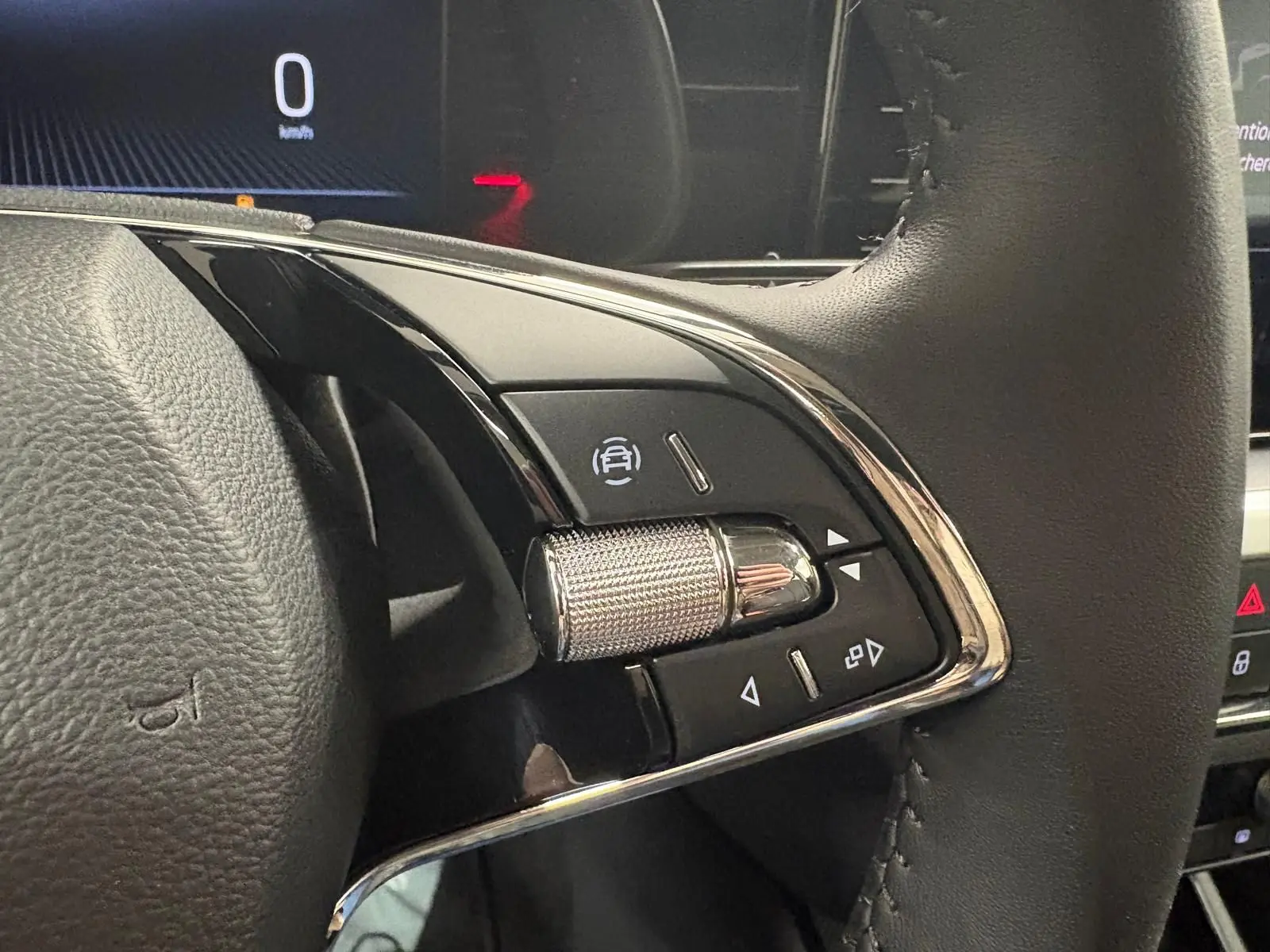 Gros plan sur les commandes à droite du volant du Skoda Kamiq 2023, finition Business, avec molette métallique et boutons noirs.
