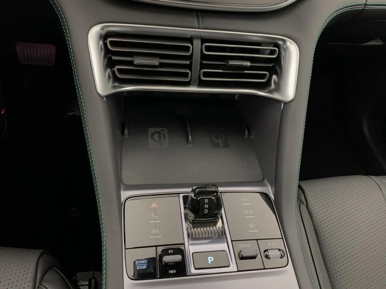Vue rapprochée de la console centrale du BYD SEAL U 1.5 DM-i 2025, avec boîte auto et surface de charge sans fil noire.
