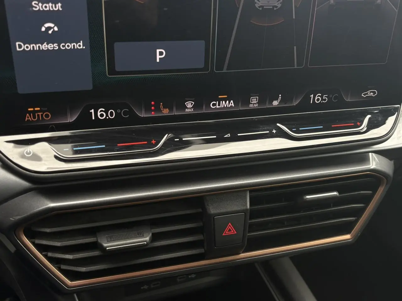 Gros plan sur la console centrale du CUPRA Formentor 2025, affichage digital de la climatisation et aérateurs noirs avec contour cuivre.