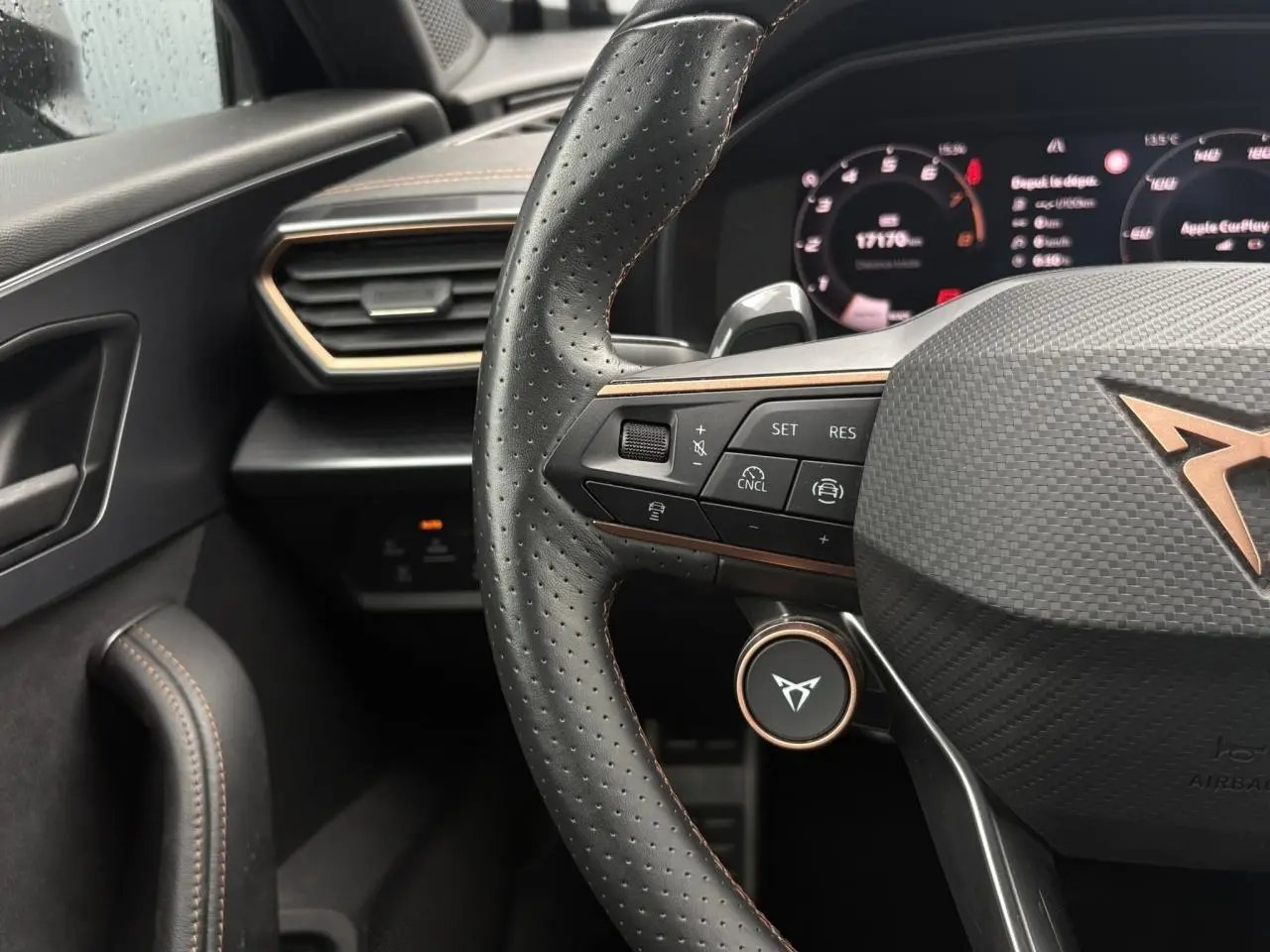 Vue rapprochée du volant cuir perforé noir avec logo CUPRA cuivré et commandes multifonctions du CUPRA Formentor 2025.