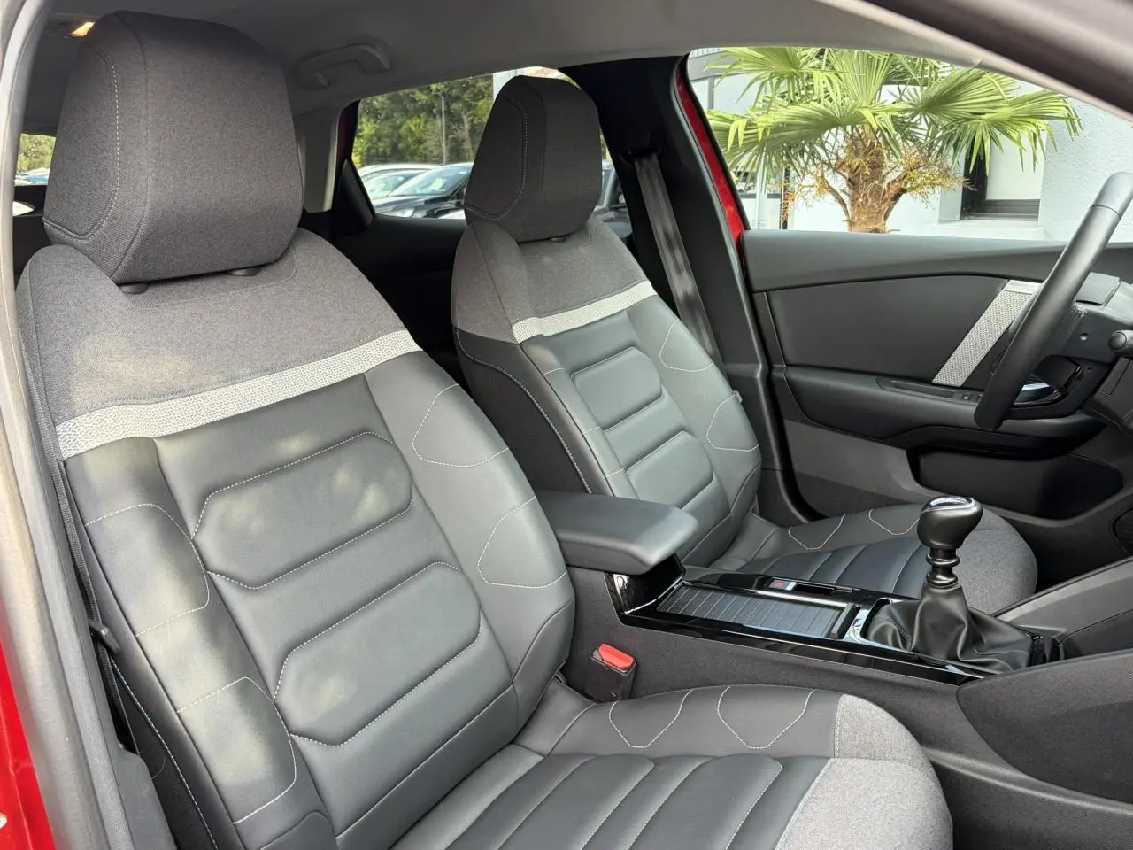 Vue intérieure côté avant droit de la Citroën C4 1.2 PureTech 130 Max avec sièges Advanced Comfort gris et volant cuir.