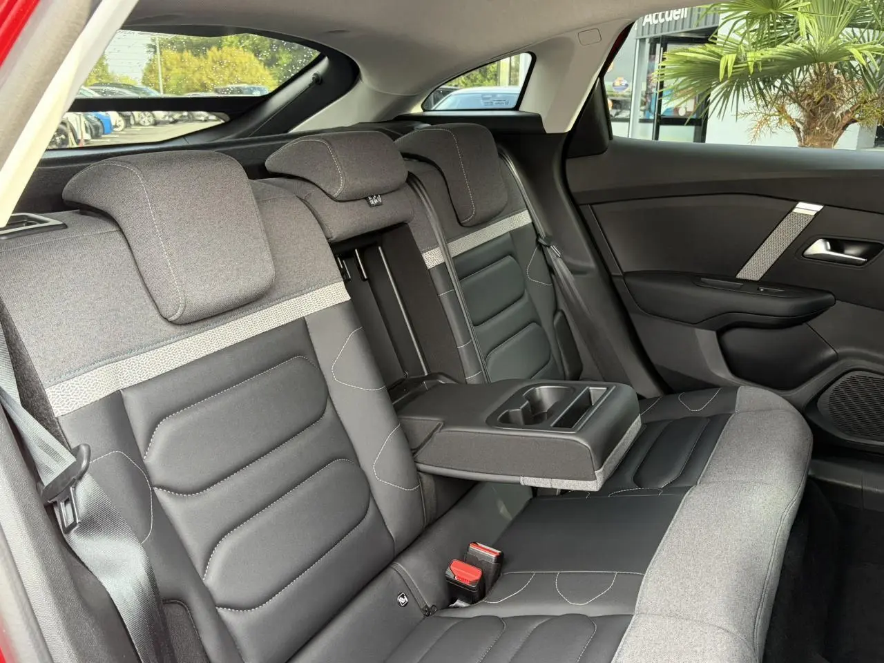 Vue intérieure côté droit des sièges arrière gris et noir avec accoudoir central déplié de la Citroën C4 2024.