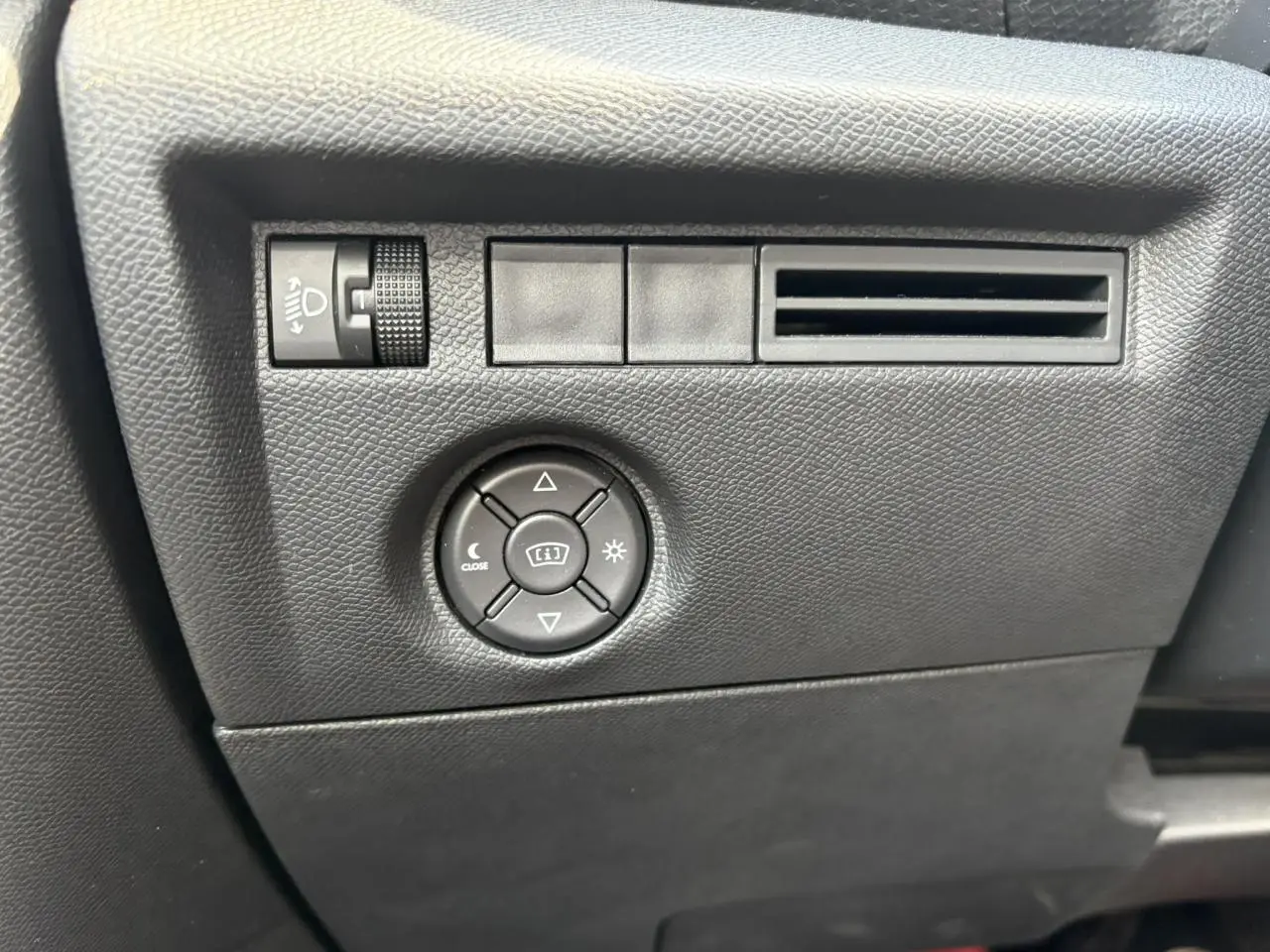 Détail du tableau de bord noir de la Citroën C4 1.2 PureTech 130 Max avec commandes d’éclairage et aérateur.