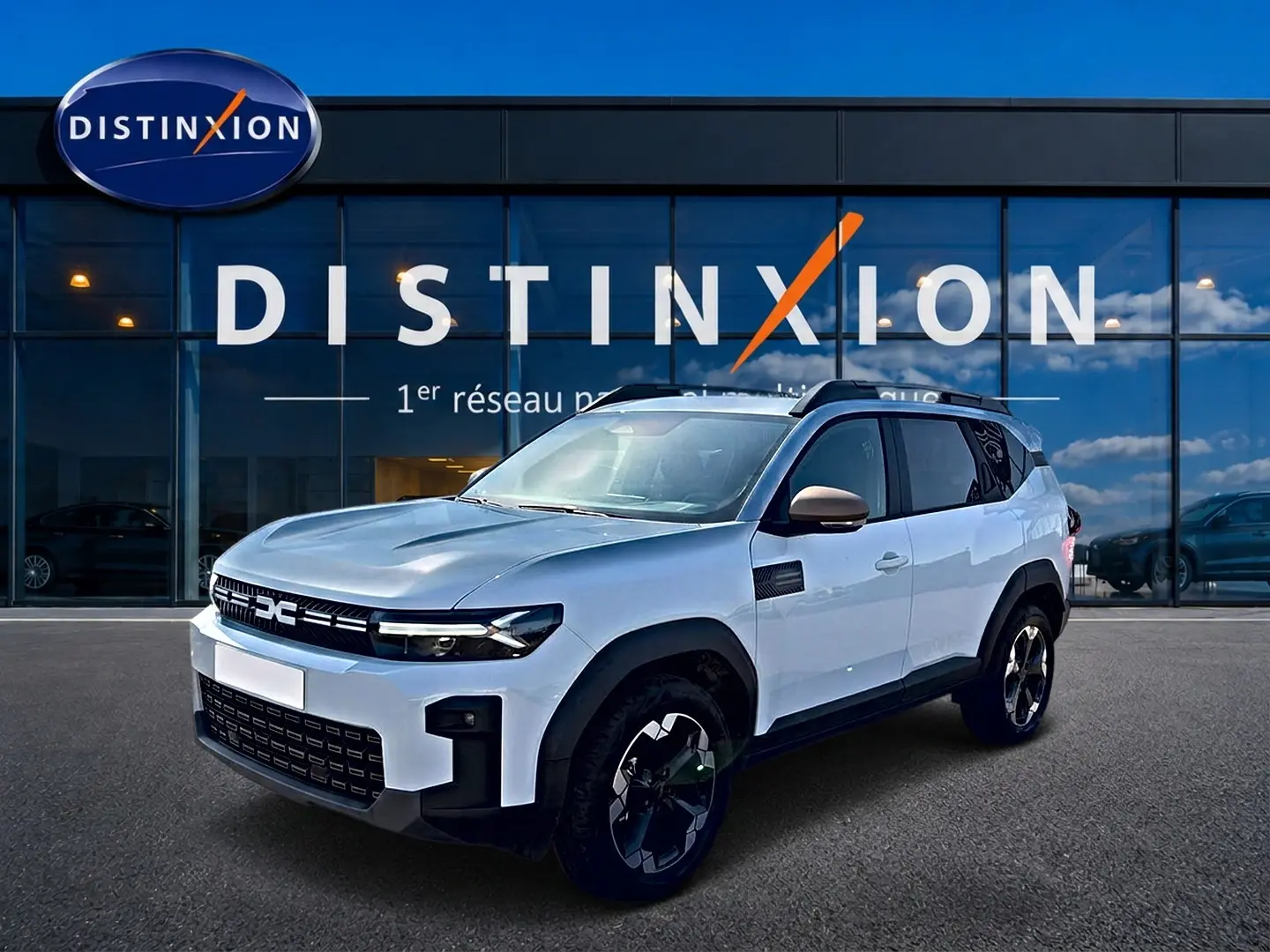 SUV Dacia Bigster blanc vu en 3/4 avant droit, avec jantes noires et barres de toit visibles.
