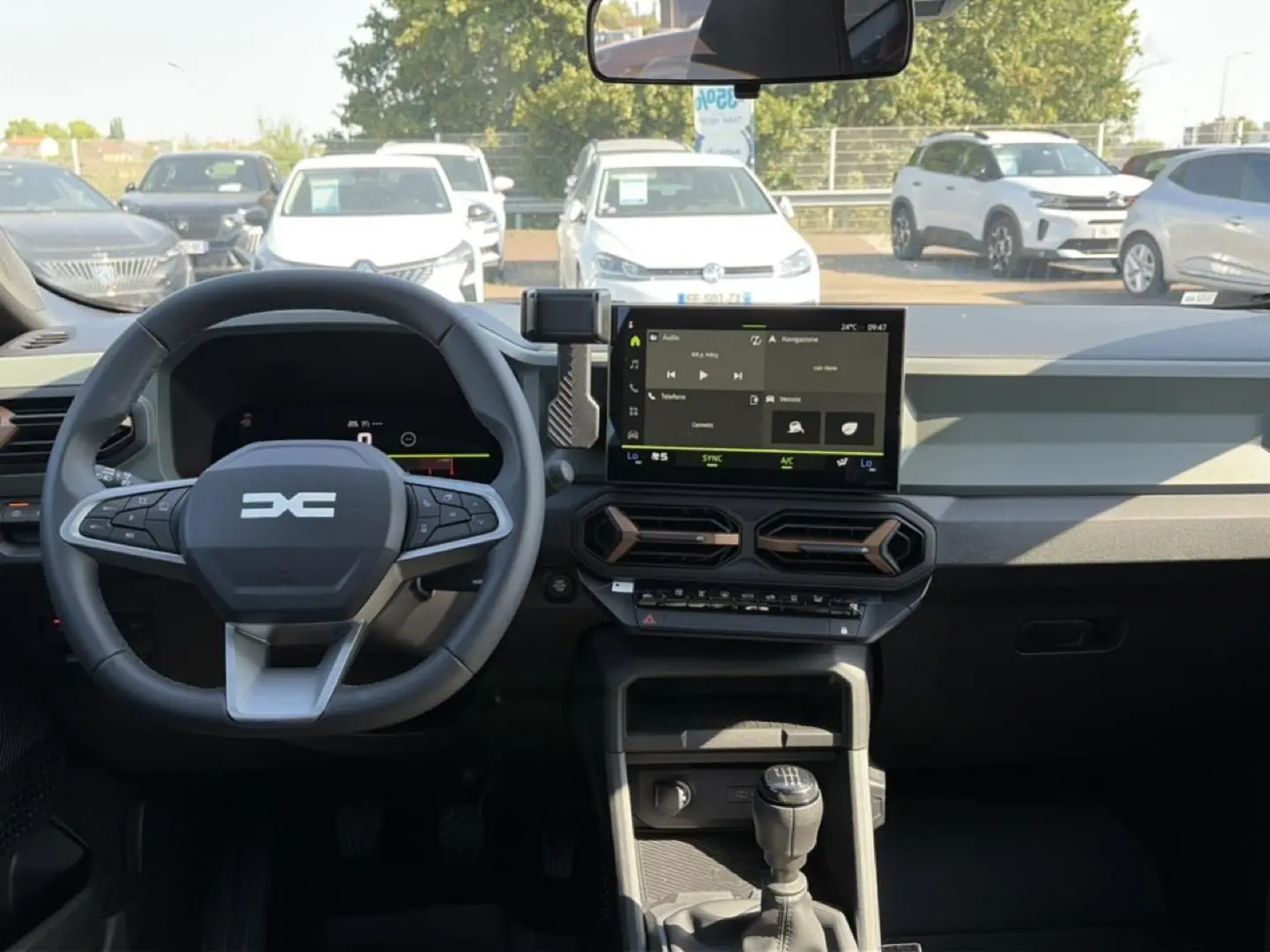 Vue intérieure du tableau de bord du Dacia Bigster blanc 2026, volant multifonction et écran tactile central visible.