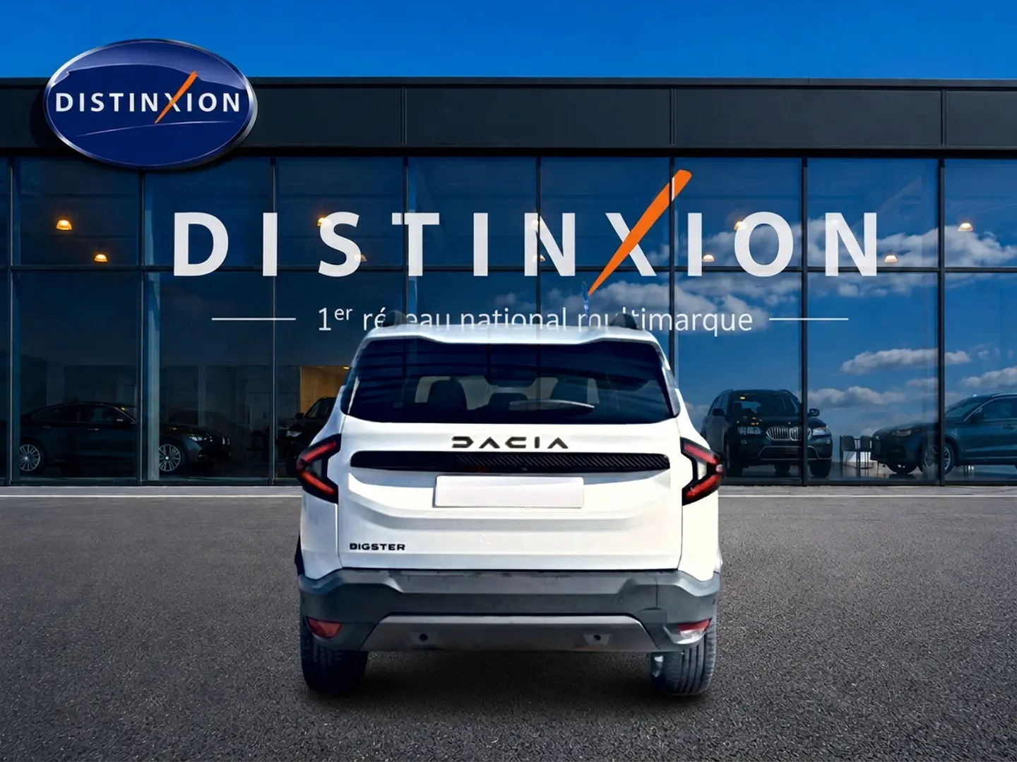 Vue arrière du Dacia Bigster blanc 2026 avec feux arrière en forme de C et logo DACIA noir sur fond blanc.