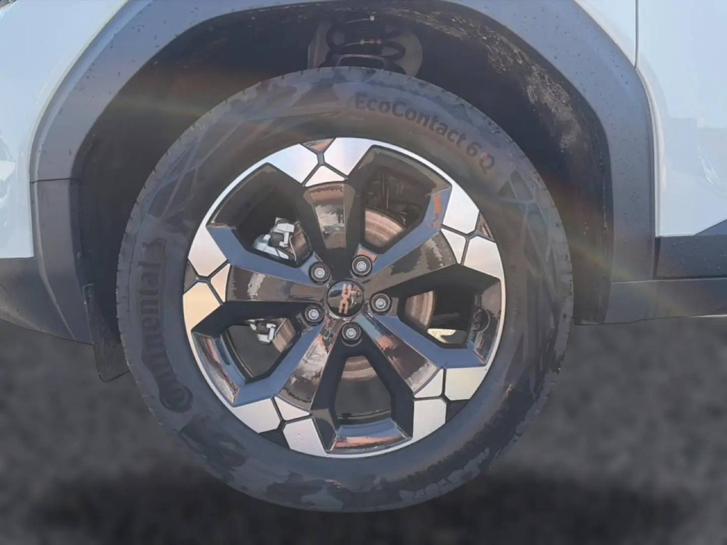 Gros plan sur la roue avant droite du Dacia Bigster blanc, jante alu bicolore au design géométrique.